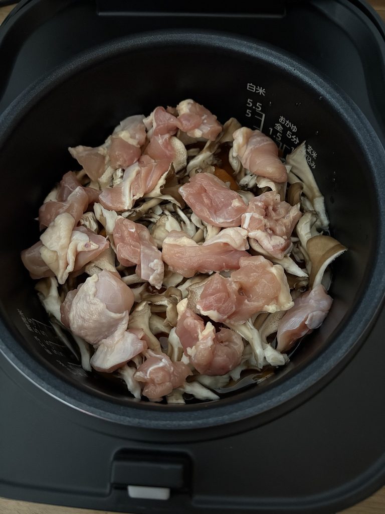 炊飯器に鶏もも肉・ごぼう・にんじん・まいたけを入れたところ