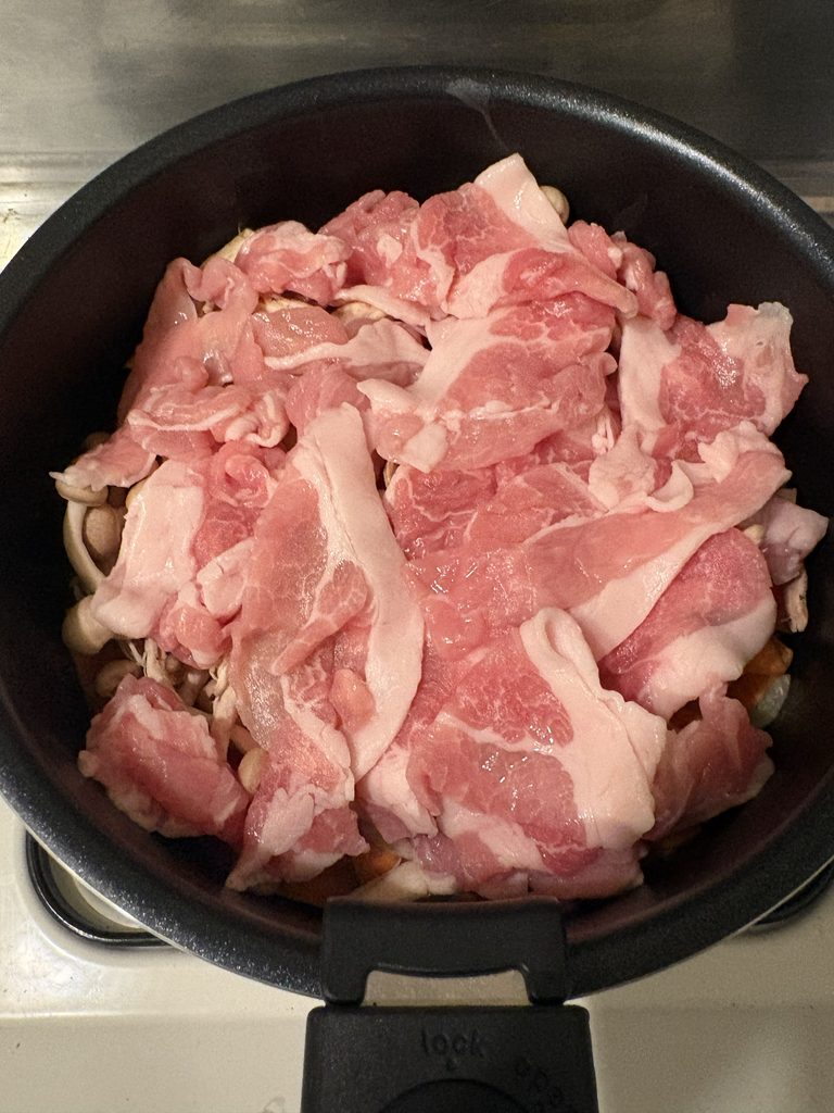 野菜の上に豚こまをのせた味噌煮の調理途中