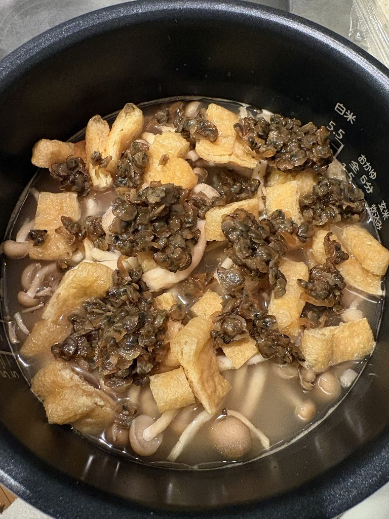 しじみ佃煮と冷凍具材をのせた炊飯前の炊き込みご飯